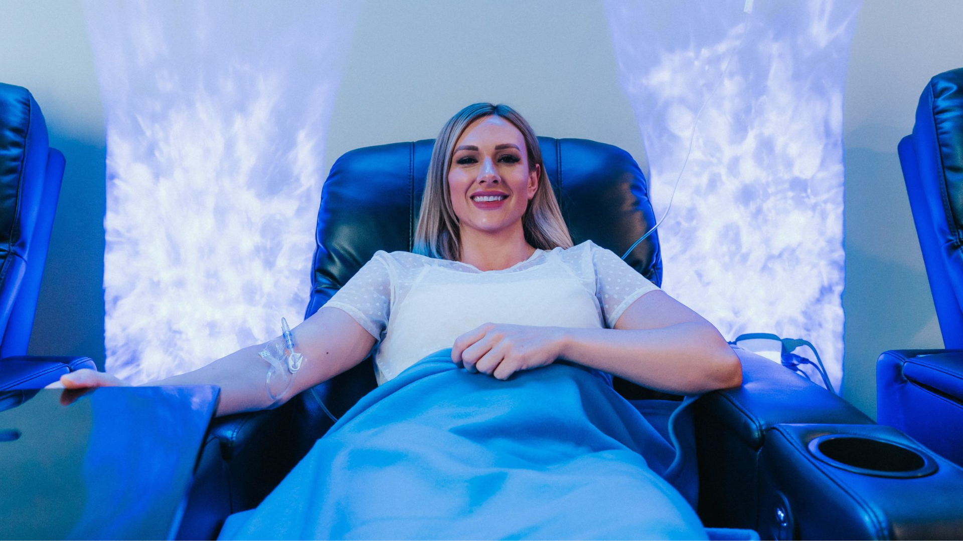Patient receiving IV infusion therapy in a relaxing wellness lounge setting